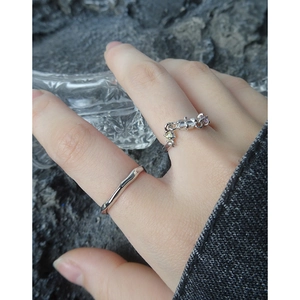 S925 Silberkettenringe-Set mit bunten Zirkonsteinen auf der Hand mit Steinhintergrund