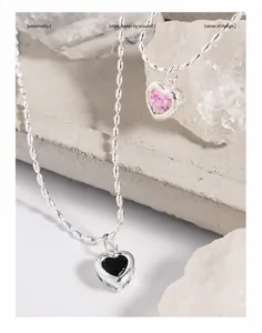 Macro shot of S925 silver heart necklaces with pink and black zircon on white stones