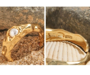 Makro-Detail des S925-Stempels auf dem goldfarbenen Lava-Ring mit weißer Perle