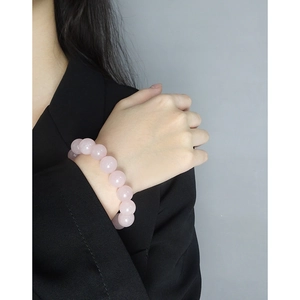 Pink quartz bead bracelet with S925 silver accents on a model's wrist over black suit