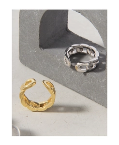 Close-up of adjustable Cuban chain rings in gold and silver finishes on a stone surface