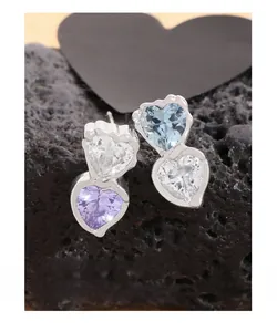 Macro shot of S925 silver earrings featuring heart-cut blue and purple cubic zirconia