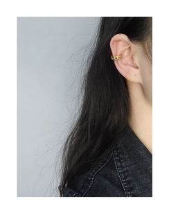 Close-up of a minimalist golden cuban link ear cuff worn on the cartilage without piercing