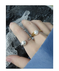 Close-up of gold and silver S925 sterling silver rings with large pearls on a hand