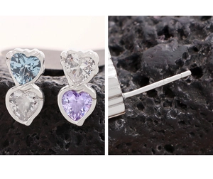 Macro shot of S925 sterling silver heart studs with colorful zircons on volcanic rock