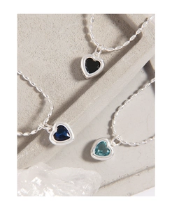 Close-up of S925 silver bracelets with heart-shaped black and blue zircon pendants