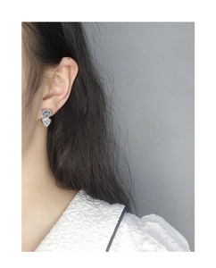 Detail of S925 silver earrings with light blue and white heart-shaped zircon stones
