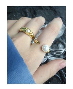 Detail of S925 silver gold-plated ring with lava texture and elegant white pearls