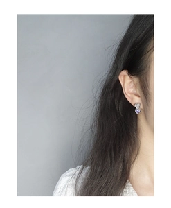Detail of S925 silver stud earrings with stacked white and purple zircon heart stones