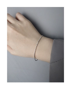 Gros plan détaillé d'un bracelet de perles minimaliste en argent sterling S925 au poignet
