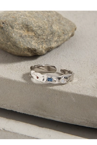 Close-up of S925 sterling silver ring with textured surface and three colored gemstones