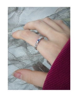 Detail of silver S925 ring with irregular lava texture and inlaid colorful zircons