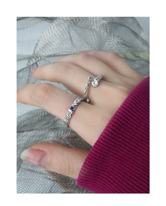 Detailed view of silver textured rings featuring colorful zircons on a hand