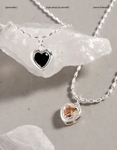 Détail de colliers en argent S925 avec pendentifs cœur en zircon noir et champagne