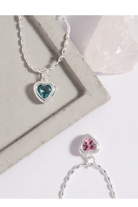 Détail d'une chevillère en argent avec cœur serti de zircons bleus et roses