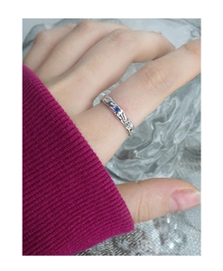 Macro detail of S925 silver ring with wrinkled texture and colorful zircon stones