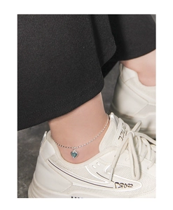 Détail de la chevillère en argent S925 avec cœur bleu portée avec des baskets