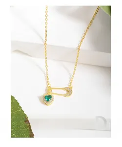 Close-up of S925 silver pin necklace with a green heart gem and zircon accents