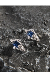 Detailed macro of S925 silver stud earring with blue zircon and irregular wrinkled texture