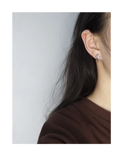 Close-up of S925 silver star stud earrings with pink zircon stone on model ear