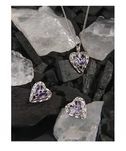 Macro shot of S925 sterling silver heart necklace set with purple zircon on charcoal background