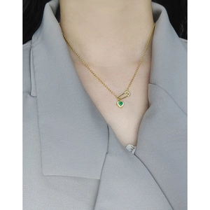 Elegant S925 silver necklace with green heart pendant and pin design on a female model