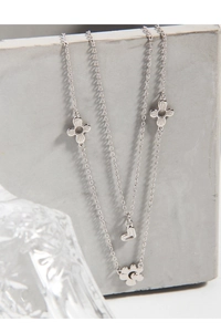Detail of silver S925 double layer necklace with heart and daisy flower charms