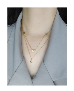 Close-up of double-layered gold S925 silver necklace with floral and heart pendants