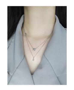 Close-up of double-layer S925 silver necklace with delicate flower and heart pendants