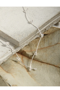 Detailed close-up of 925 sterling silver beaded chain on a leaf for a minimalist style