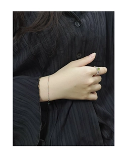 Detail of S925 silver rainbow bead bracelet and gemstone ring on model wearing black