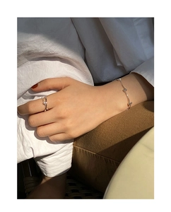 Close-up of minimalist S925 sterling silver segmented bracelet and pearl ring on model