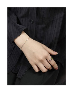 Detail of S925 silver bamboo chain bracelet with colorful beads and gemstone rings on hand