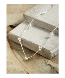 Detailed view of S925 sterling silver segmented bead chain on a textured stone surface