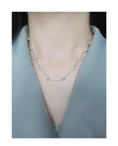 Close-up of minimalist S925 sterling silver beaded chain necklace on a model
