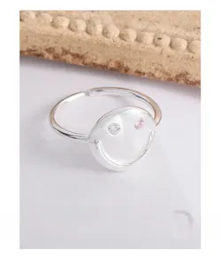 Detail of adjustable S925 silver smiley face ring with pink and white cubic zirconia