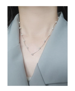 Detailed view of S925 sterling silver beaded necklace on a grey blazer neckline