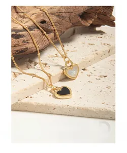 Gros plan de pendentifs en forme de cœur dorés avec incrustations noires et blanches