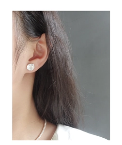 Minimalistischer S925 Sterling Silber Smiley Ohrstecker getragen von einem Modell vor Grau