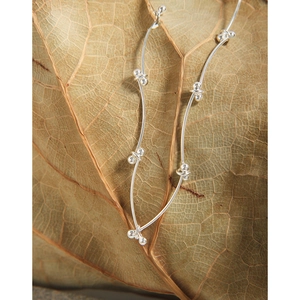 Minimalist S925 sterling silver beaded chain necklace displayed on a textured dried leaf