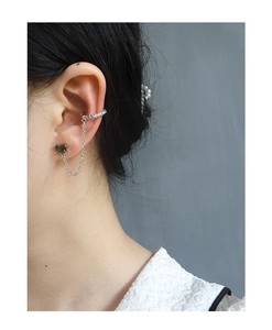 Detail of S925 silver ear cuff with chain and square green gemstone on model