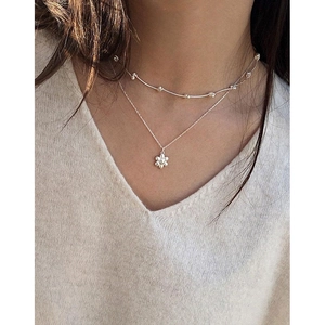 Elegant S925 sterling silver layered necklace with small floral pendant on neck