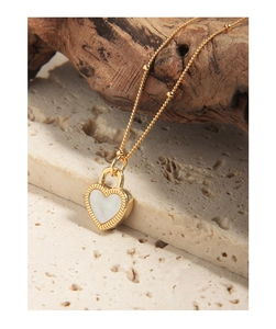 Vue macro détaillée du pendentif cœur avec incrustation blanche sur fond en pierre naturelle