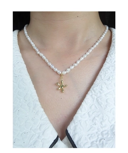 Dettaglio della collana di perle d'acqua dolce con ciondolo a stella marina dorata
