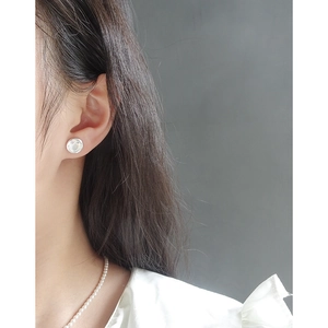 Minimalistischer S925 Sterlingsilber Smiley Ohrstecker getragen von einem Modell im Licht