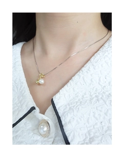 Dettaglio della collana in argento S925 con una perla bianca naturale e ciondolo dorato