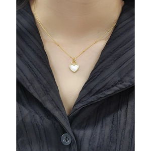 Collier en argent S925 doré avec pendentif cœur en nacre porté par un mannequin