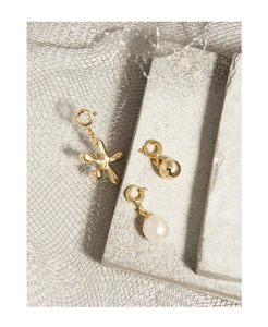Dettaglio di pendenti in argento S925 placcato oro con stella marina, sfera e perla