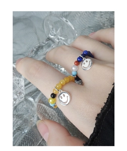 Dettaglio dei ciondoli smiley in argento S925 su anelli elastici con perline colorate