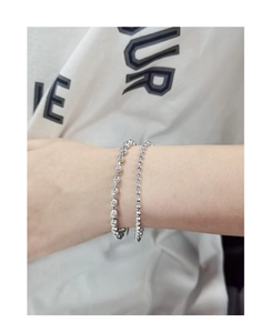 Gros plan de bracelets à billes en argent sterling S925 poli de deux tailles au poignet